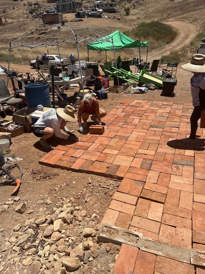 Volunteers laying a brick paver patio