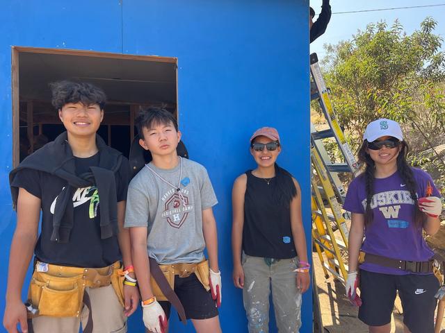 A summer build crew at a blue home